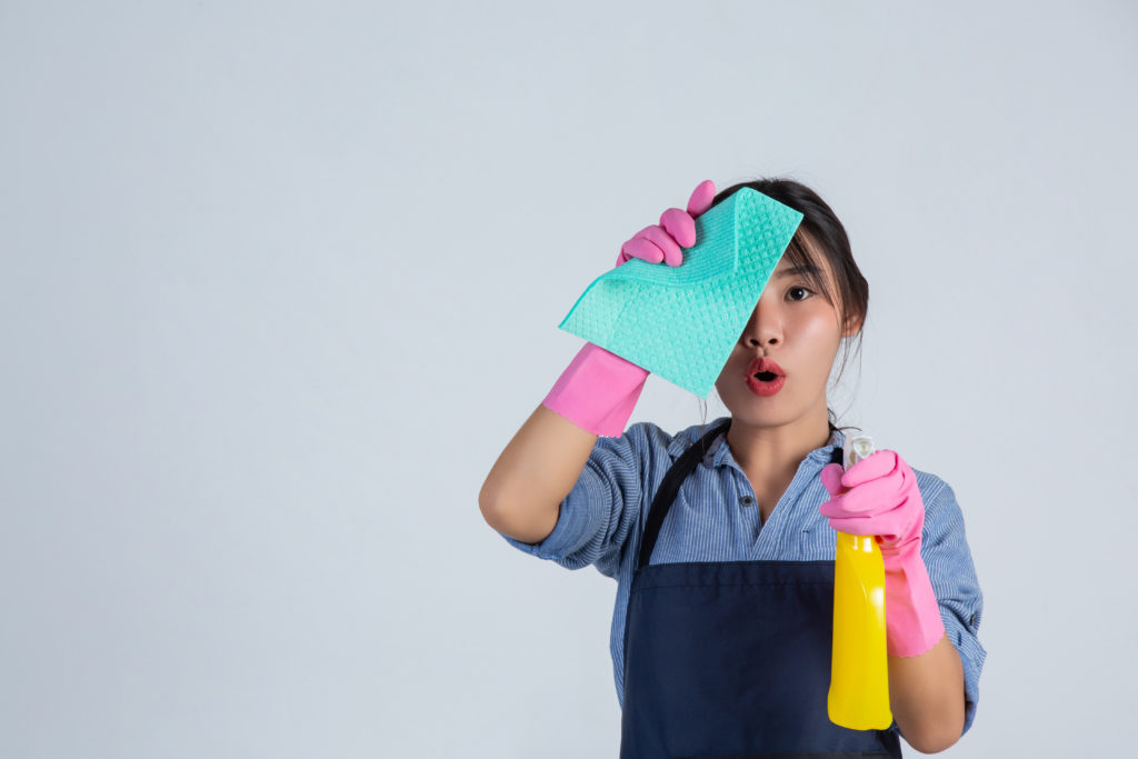 Mujer con guantes rosas perteneciente a una empresa de limpieza de oficinas