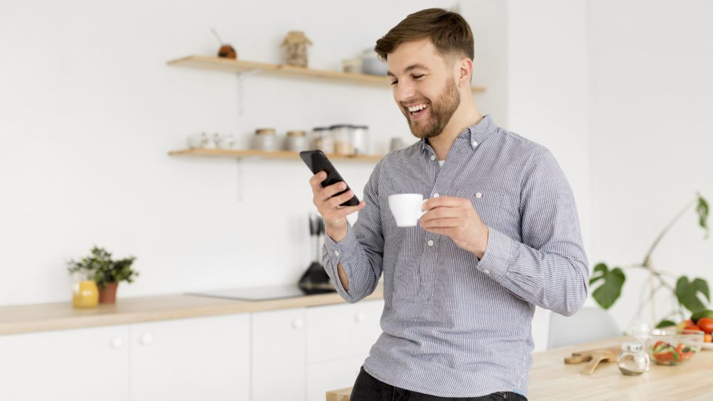 Hombre con taza de café monitoreando apps seguridad para el hogar